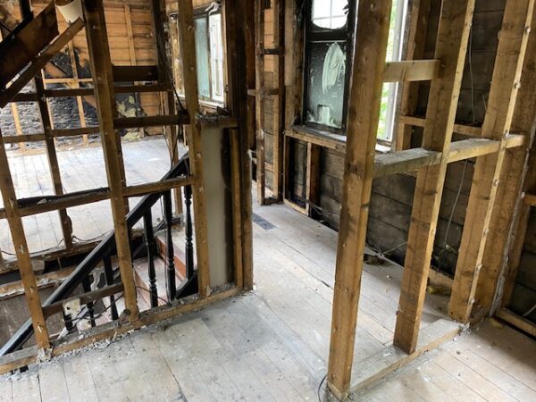 Internal view of room with bare brickwork on gable end and exposed beams on walls and floor. House Fire Insurance Reinstatement Lanark