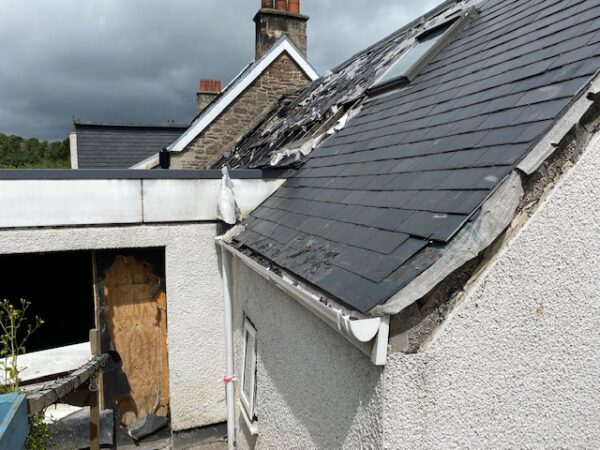 External view of property with partially damaged roof with exposed beams. House Fire Insurance Reinstatement Lanark