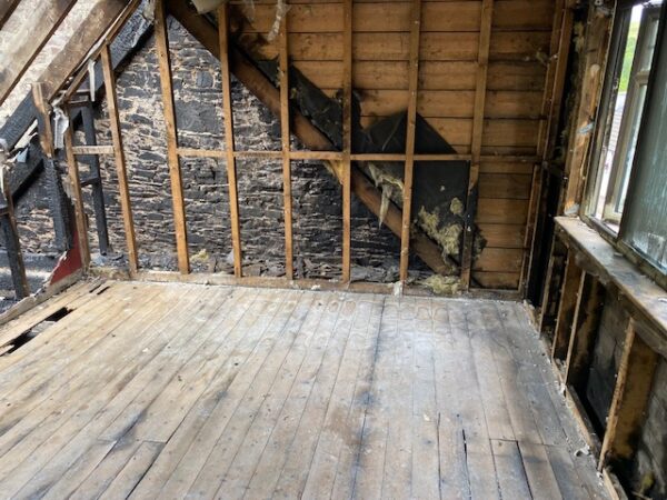 Internal view of room with bare brickwork on gable end and exposed beams on walls and floor. House Fire Insurance Reinstatement Lanark