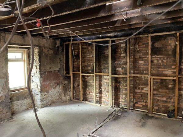 Internal view of room with bare brickwork, exposed beams and cabling. House Fire Insurance Reinstatement Lanark