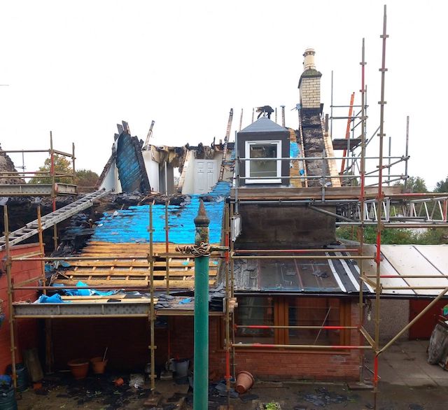 Exterior view of fire damaged home with scaffolding and rebuilding - blog feature