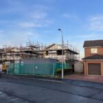 Exterior view of houses with scaffolds and safety fences in place. new build blog