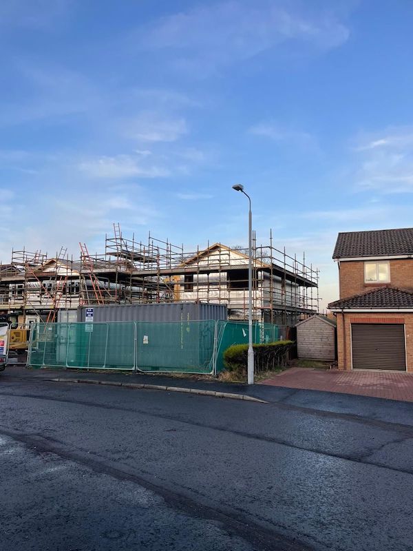 Exterior view of houses with scaffolds and safety fences in place. new build blog