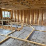 Interior view of upper floor of house with wooden beams and slats in place. new build blog