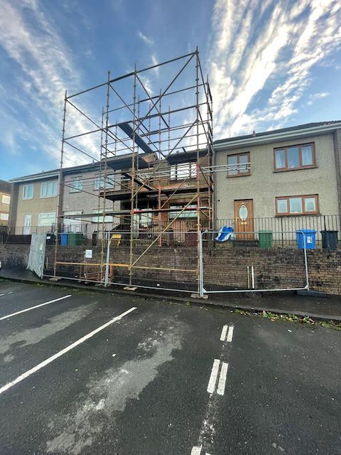 External view of house with top hat scaffold and safety fencing in front. blog feature
